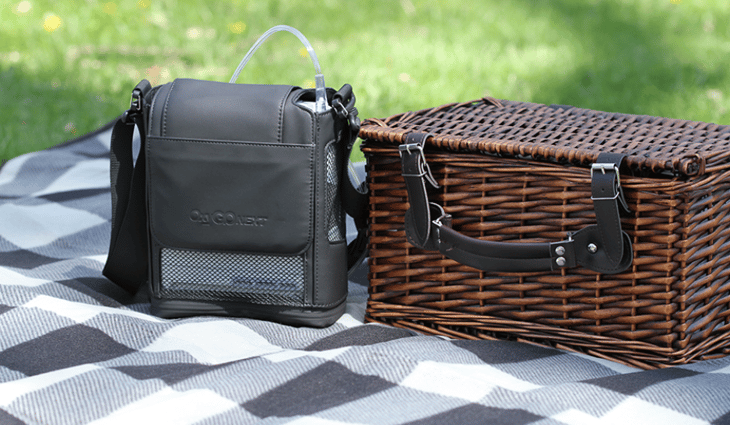 OxyGo NEXT on a blanket next to a picnic basket.